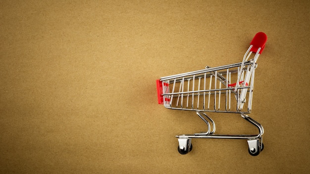 Empty shopping cart on brown paper background