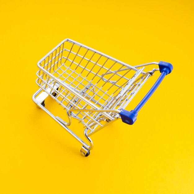 Empty shopping cart over yellow background