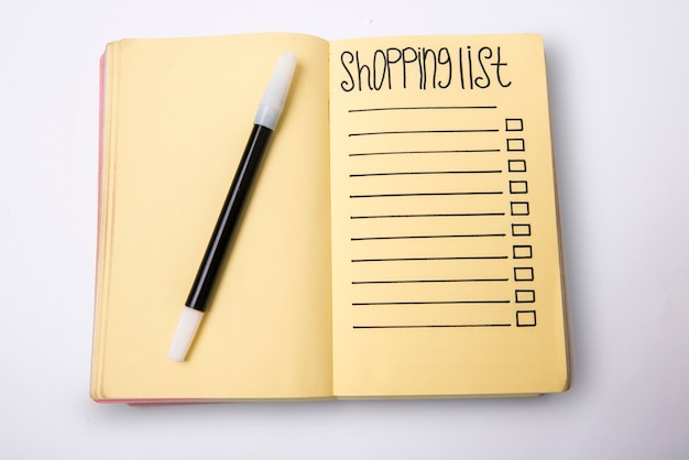 Empty shopping list text on a note pad with black marker on white background