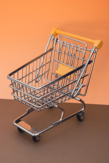 Empty shopping trolley cart on beige background copy space text\
online shopping buy mall market