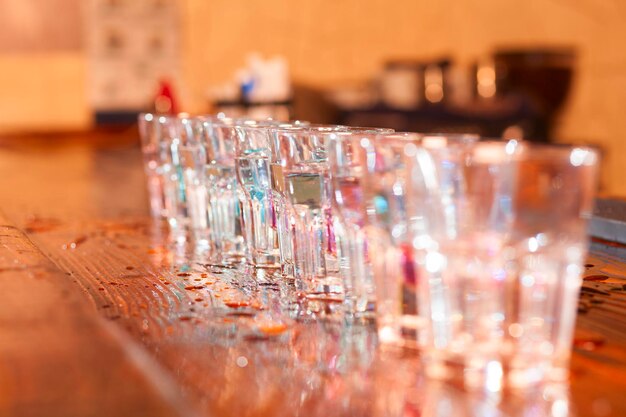 Empty short glasses standing in row on bar