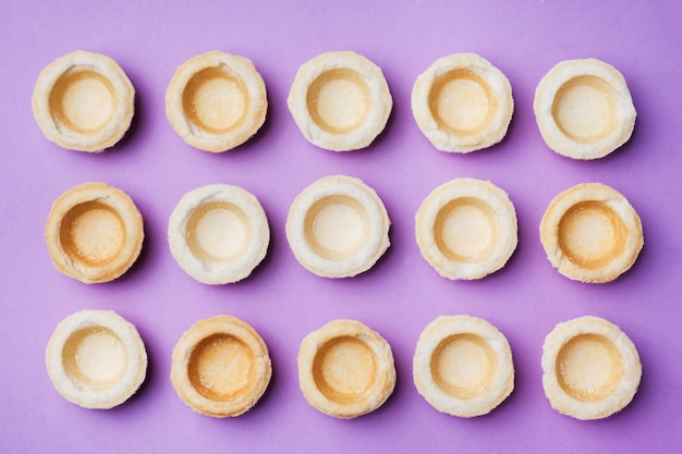 Empty shortbread tartlets laid out in a row.