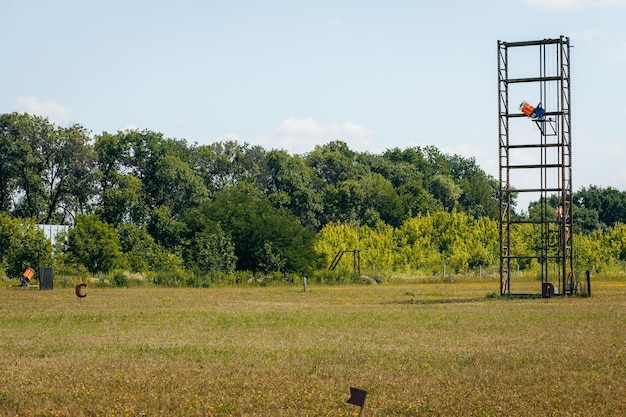 Campo di addestramento per fucili vuoto con erba verde e macchine plat