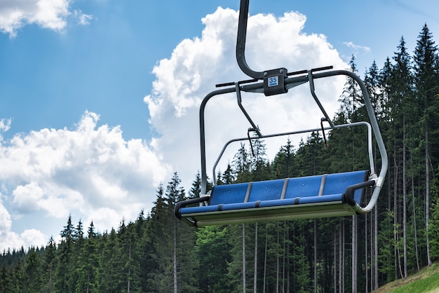 Ascensore di sci vuoto sulla foresta e sul cielo blu. vacanze in montagna in estate. ecoturismo