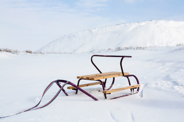 Foto slitta vuota con sulla neve sullo sfondo della slagheap