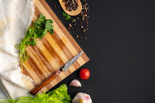 Empty slicing or cut board on the table, herbs and spices laying around on the tables