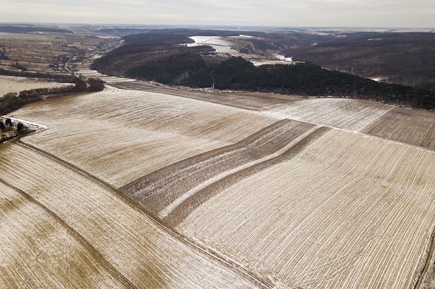 Empty snowy fields and woody hills