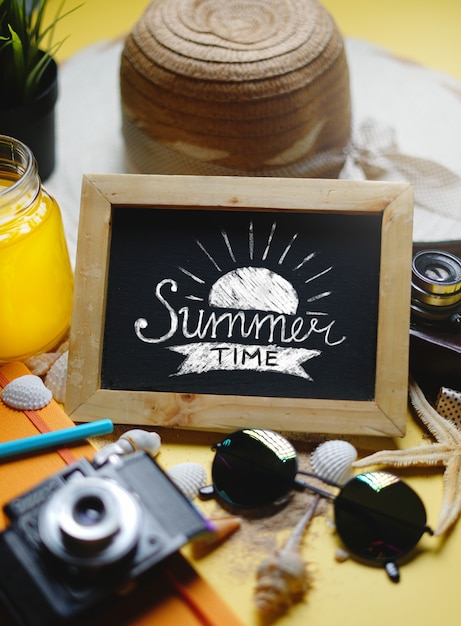 Photo empty space blackboard between summer beach accessories on yellow background