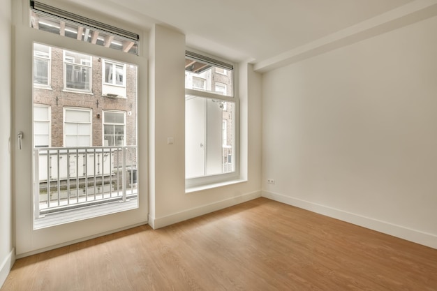 An empty spacious room in bright colors and with a large window and access to the balcony