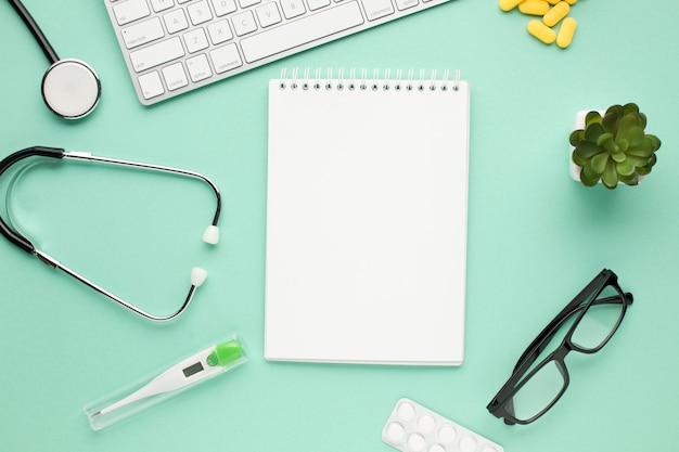 Photo empty spiral diary with medical equipment on doctor's desk