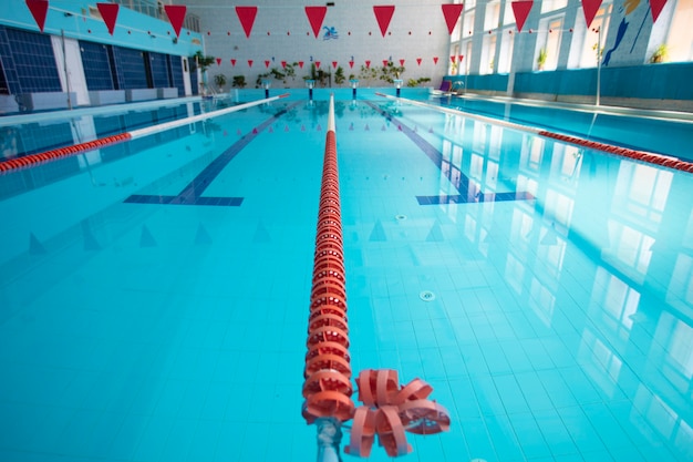 An empty sports pool with a red dividing path. Blue water in the swimming pool.