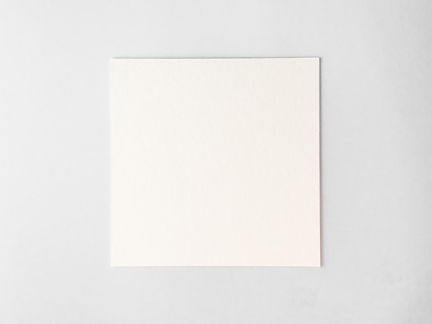 Photo empty square cardboard sheet on a white table. empty space for text