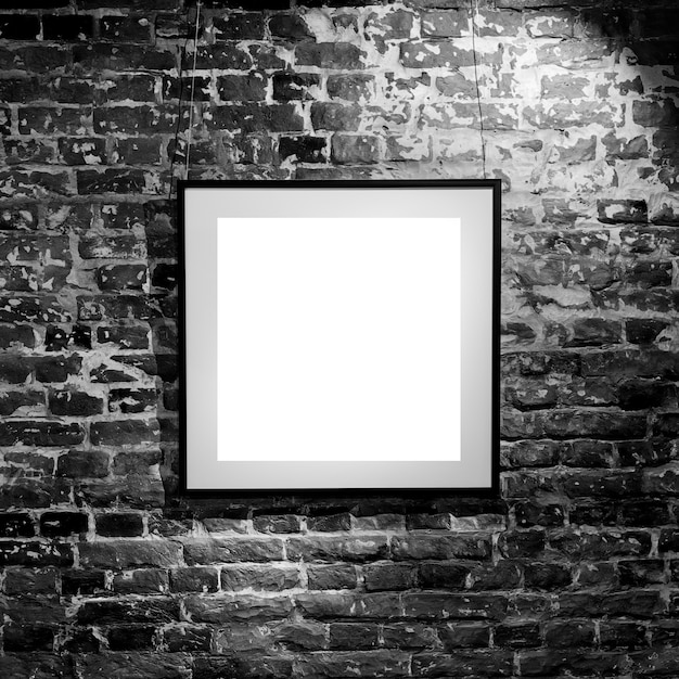 Пустая квадратная рамка на черной кирпичной стене. Плакат пустого пространства или рамка искусства ждать быть заполненным. Квадратная черная рамка