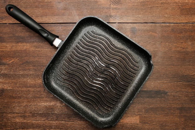 Photo empty square grill pan on wooden table