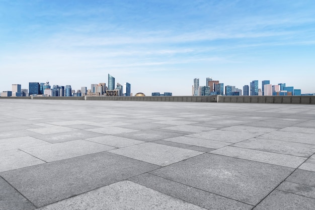 Empty square tiles and skyline of urban buildings