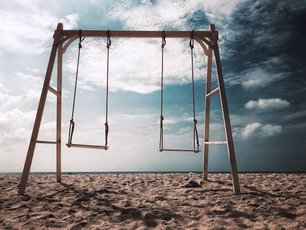 Photo empty swing on beach against sky