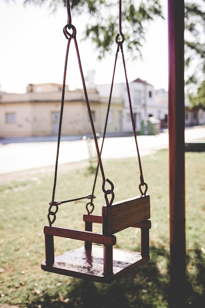 An empty swing set at a playground. Swing alone in a neighborhood park.