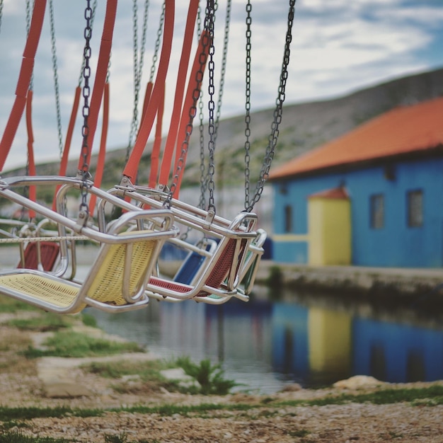 Foto swings vuoti sulla riva del lago da casa contro il cielo