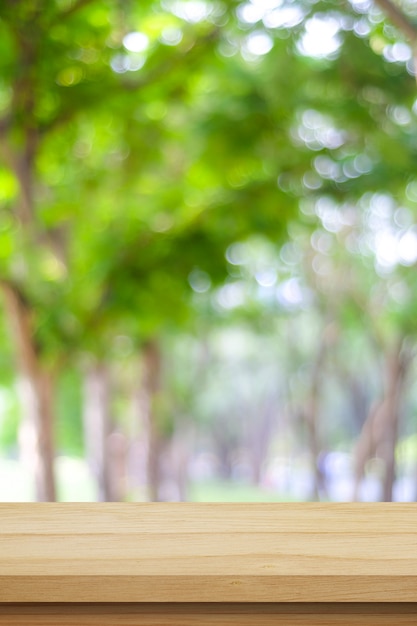 Empty table over blur green tree background