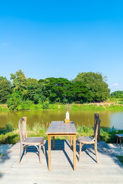 川の景色と青い空と空のテーブルと椅子