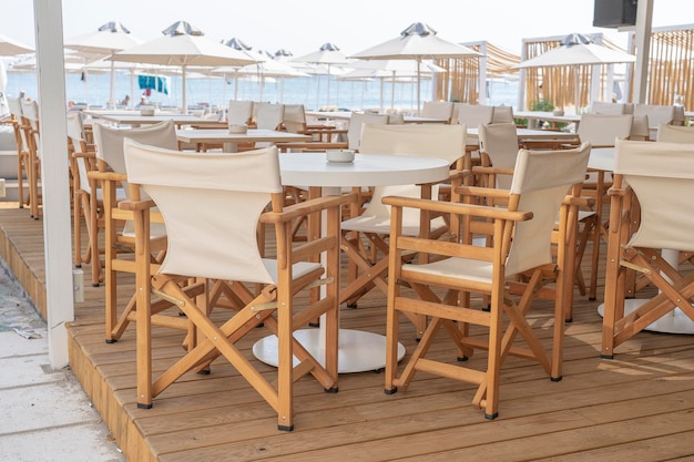 Empty table and chairs in restaurant Greece Beach cafe near sea outdoors Travel and vacation concept