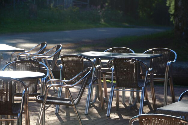 Photo empty tables and chairs arranged at sidewalk cafe