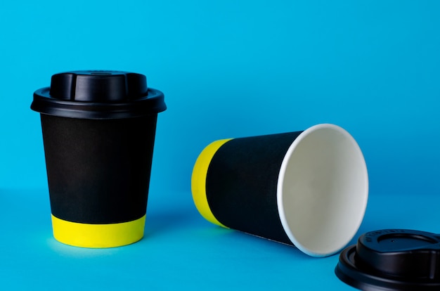 Empty take away coffee paper cup on blue background. 