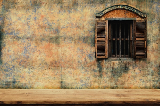 Empty top of wood chair with old cement wall and a wooden window background.