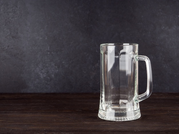 Empty transparent beer glass on wood background