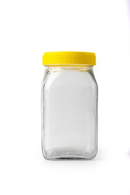 Empty transparent glass jar with yellow cap