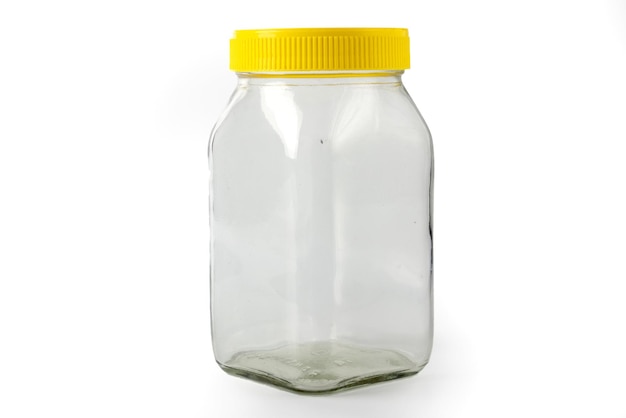 Empty transparent glass jar with yellow cap