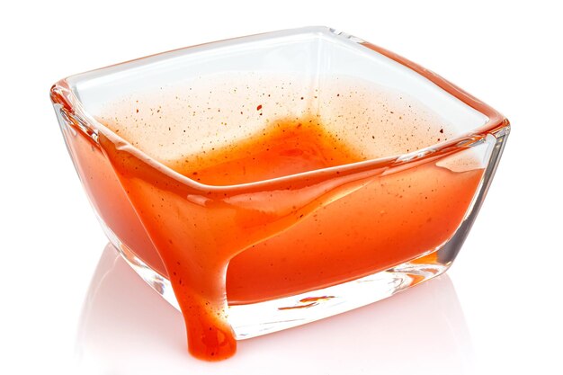 Empty transparent glass square bowl with stains and smudges of tomato ketchup isolated on white