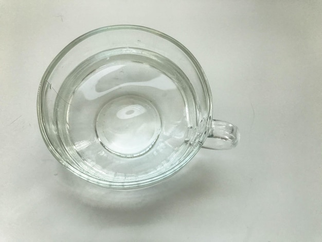 Фото Пустая прозрачная кружка круглая и большая наполненная водой стеклянная кружка с круглой ручкой чаепитие