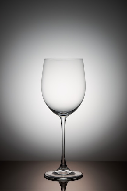 empty transparent wine glass stands on a dark glass