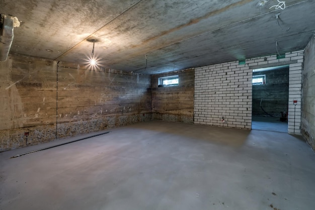 Photo empty unfurnished basement room with minimal preparatory repairs interior with white brick walls