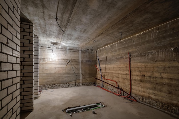 Empty unfurnished basement room with minimal preparatory repairs interior with white brick walls