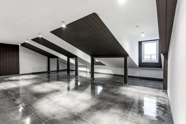 Empty unfurnished loft mansard room interior with wooden\
columns and wet concrete floor on roof level in black and whote\
style color