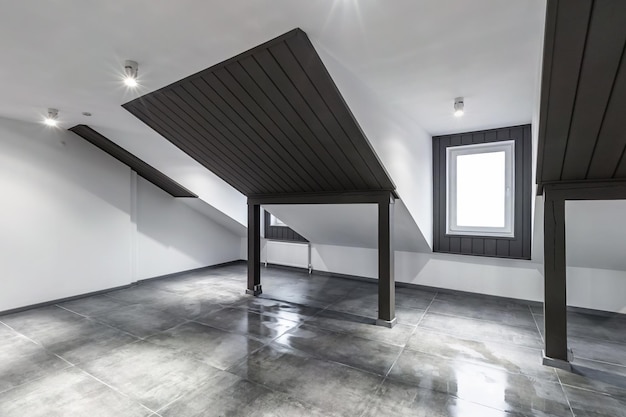 Empty unfurnished loft mansard room interior with wooden\
columns and wet concrete floor on roof level in black and whote\
style color