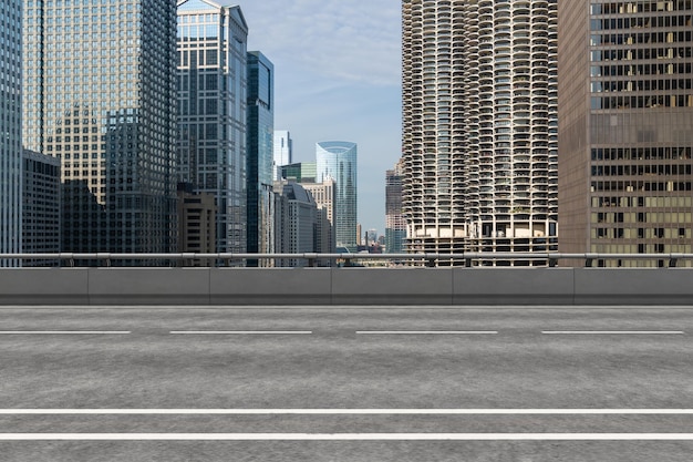 写真 都市の建物の背景を持つ空の都市アスファルト道路の外観新しい近代的な高速道路のコンクリート建設成功への道の概念輸送ロジスティック産業の迅速な配達シカゴusa