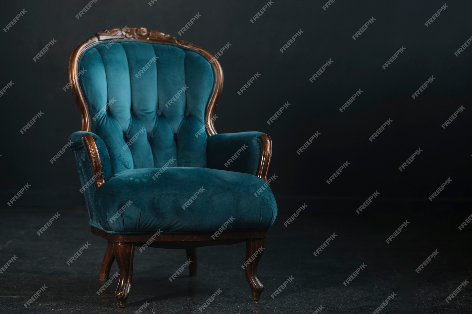 Premium Photo | An empty vintage royal blue armchair against black  background