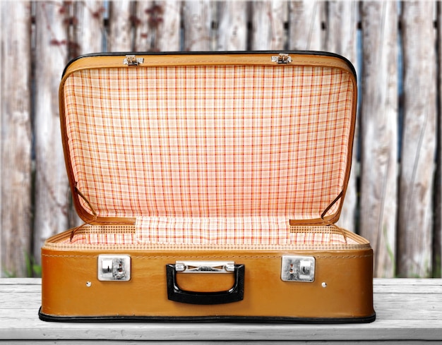 Photo empty vintage suitcase open isolated on green background