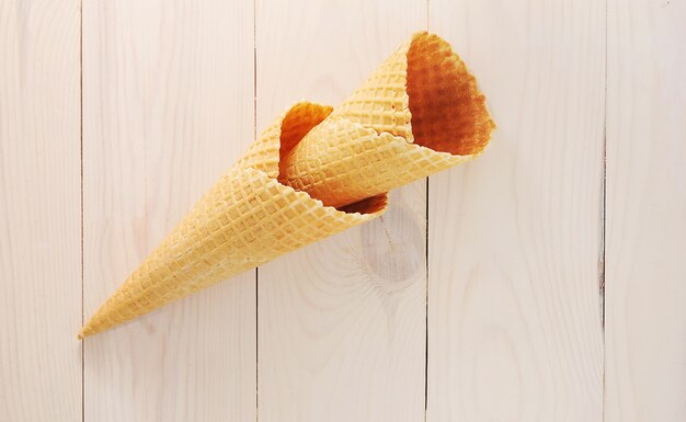 Empty waffle cone on white wooden surface