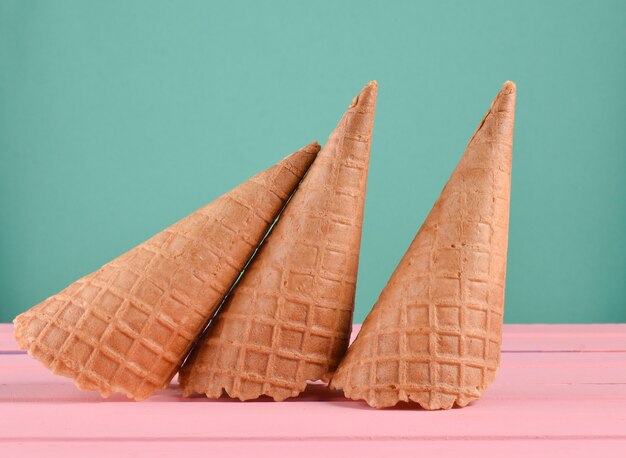 Empty waffle horns on a pink wooden table