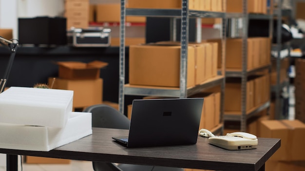 Empty warehouse depot with logistics desk and racks, storage room filled with packages of merchandise. supply chain management with products in boxes, startup business concept