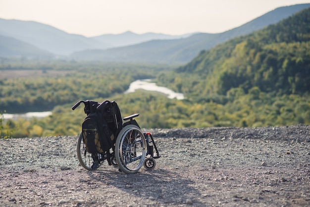 Empty wheelchair on the mountains at sunset