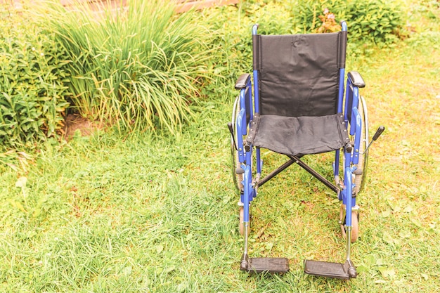 患者サービスを待っている病院の公園に立っている空の車椅子