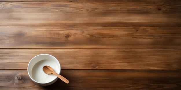 Empty white bowl and spoon on wooden table