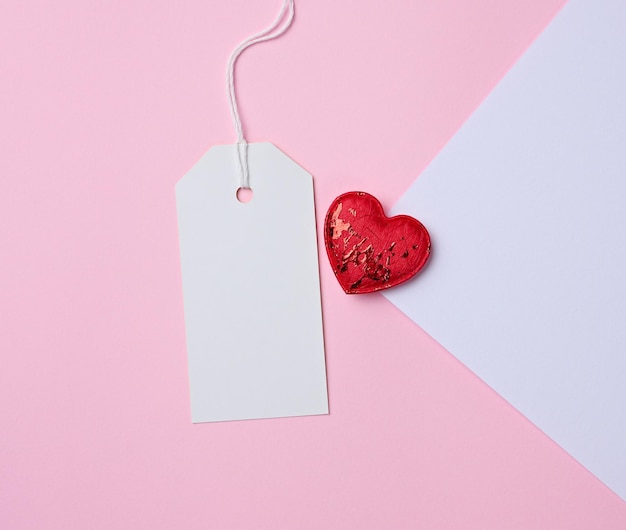 Empty white cardboard tag on a white rope pink background Preparation for the price tag