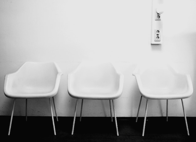 Photo empty white chairs against the wall