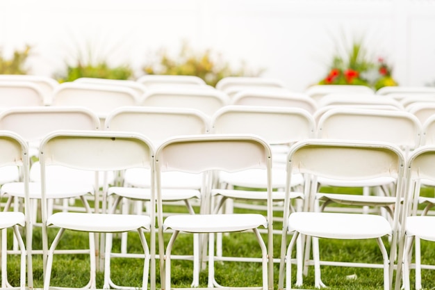 Empty white chairs before wedding ceremony.